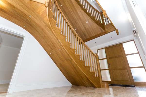 Large curved oak staircase for a three storey property with a large hallway