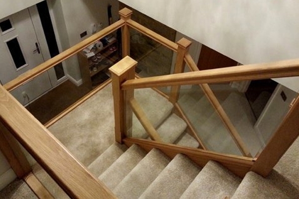 Wooden staircase for a grand hallway with glass panels for the balustrade 